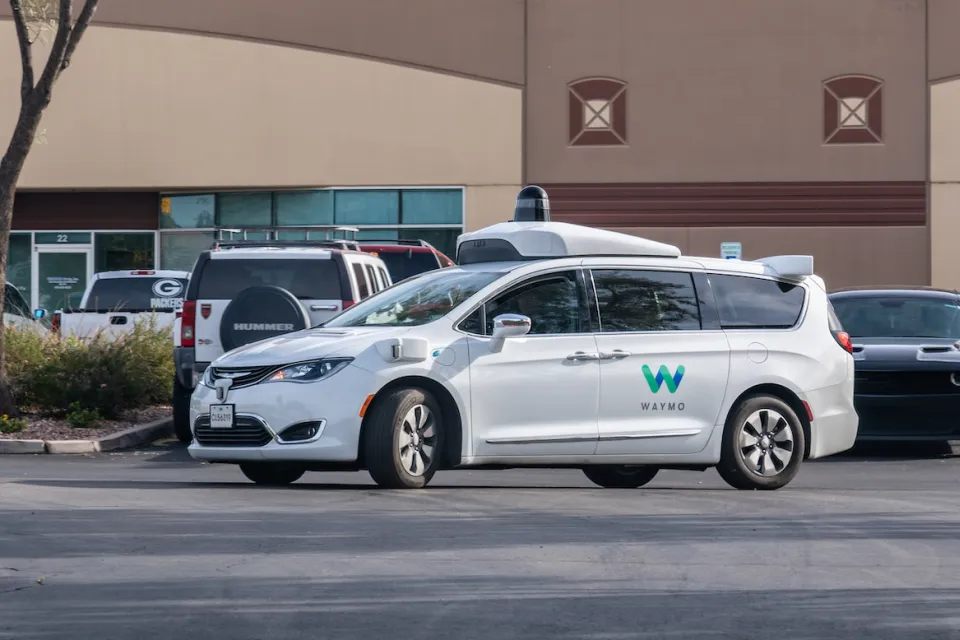 White Waymo self-driving car in parking lot in Chandler, Arizona.